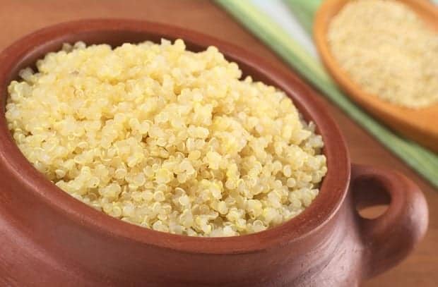 Cooked white quinoa flavoured with pineapple juice in rustic bowl
