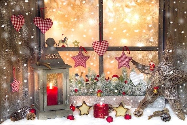 Red Christmas decoration with lantern on window sill and snow and lights