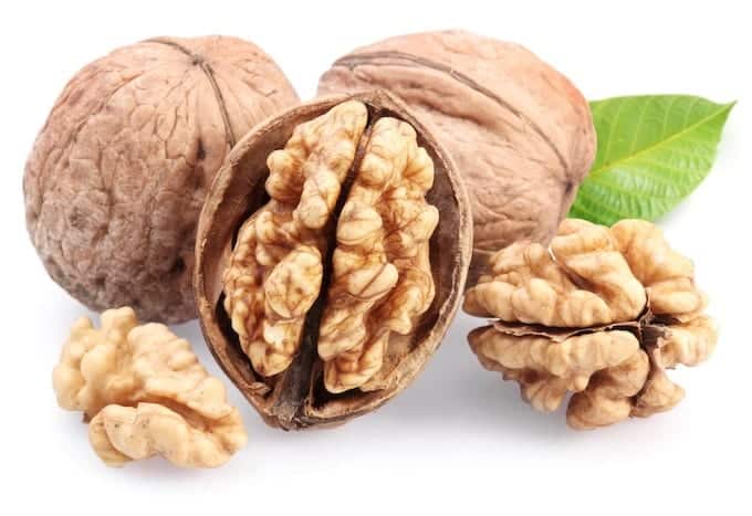 Walnuts with leaf isolated on a white background.