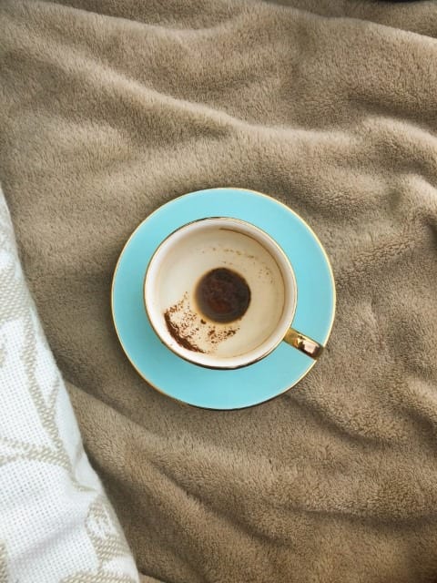 Tea cup with stains in side sitting on brown rug