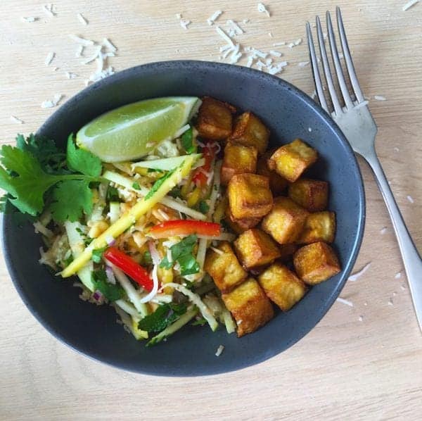 Vietnamese slaw with crispy tofu, lime and coriander in bowl with fork beside it