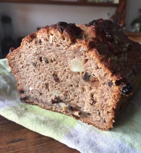 banana walnut bread cut in half on a tea towel