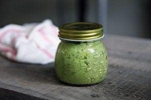 vegan dairy free pesto in a jar on a wooden table