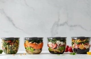 a row of nutritious salad bowls with white background