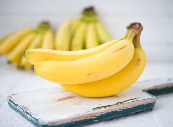 bunch of bananas on a board with other bunches in the back ground
