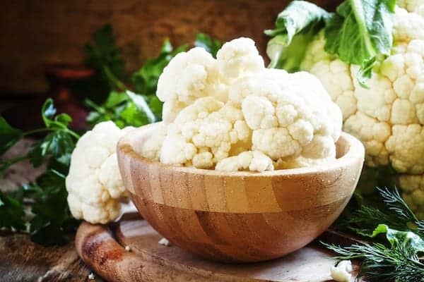 Inflorescences of cauliflower in a wooden bowl, vintage background, selective focus