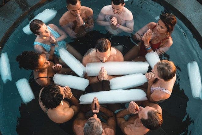 People sitting in a pool of freezing water doing the Marcel Hof method
