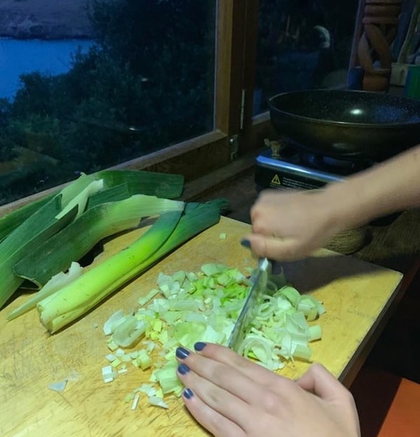 shopping leeks on a wooden board in off grid home
