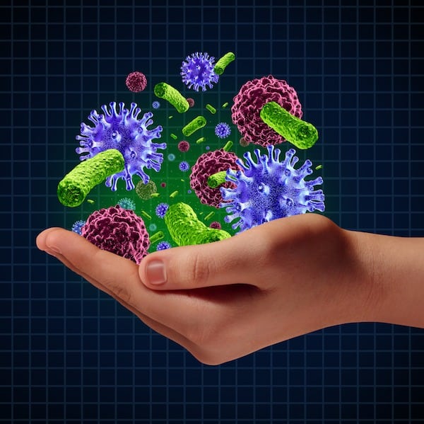 Disease risk medical health care concept with a human hand holding microscopic cancer virus and bacteria cells as a metaphor for pathogen protection from contagious disease and illness.