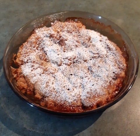 feijoa pudding sprinkled with icing sugar in a glass dish 