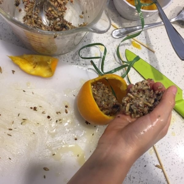 filling the orange shell with bird food mix